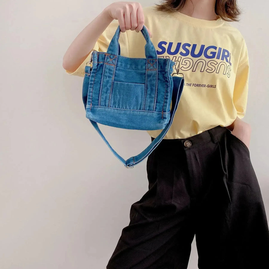 Petit sac bandoulière en jean femme à la main