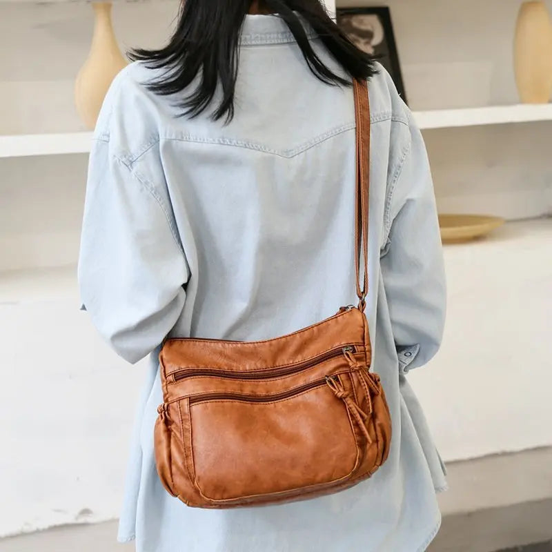 Sac bandoulière femme en cuir camel grandes poches porté dans le dos