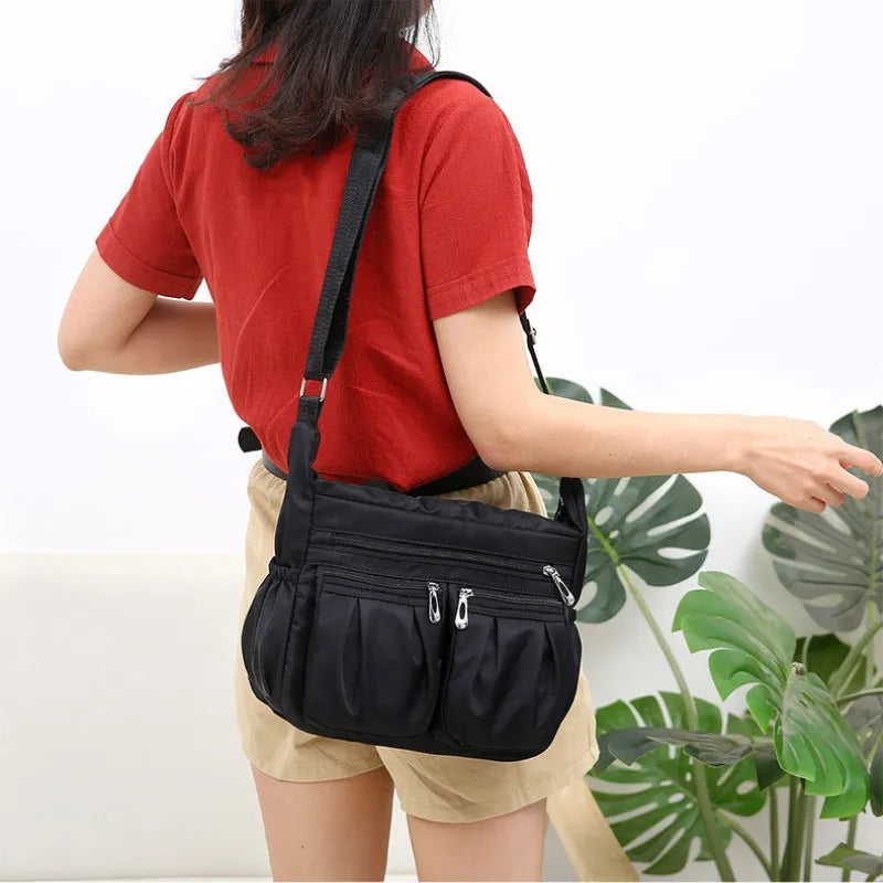 Sac bandoulière femme en tissu imperméable noir porté