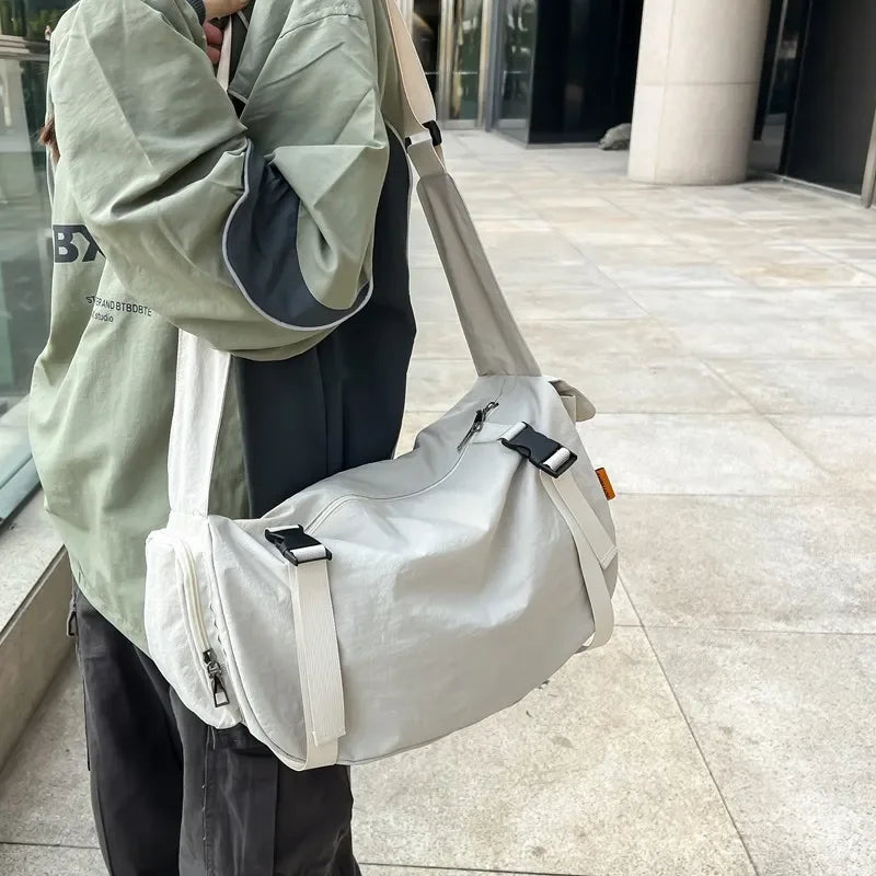 Sac bandoulière en nylon beige à l'épaule