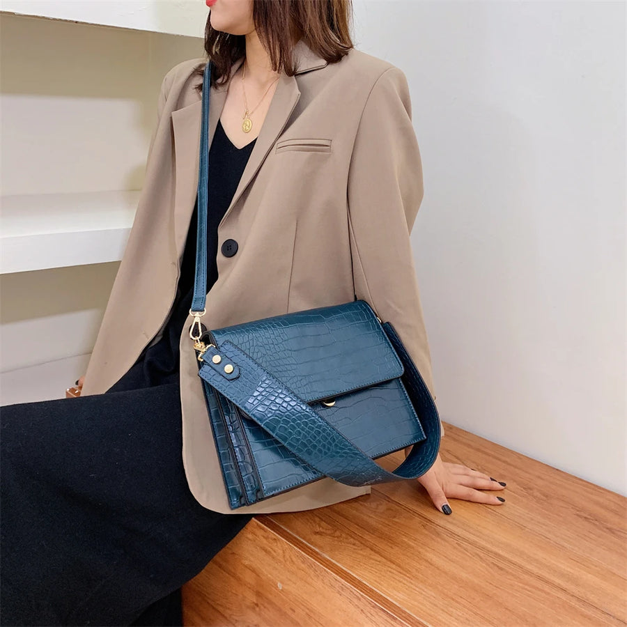 Sac imitation croco bleu porté en bandoulière