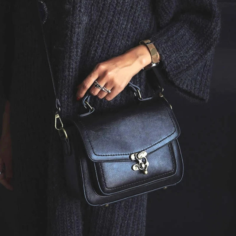 Sac à main vintage à bandoulière en cuir noir porté par femme