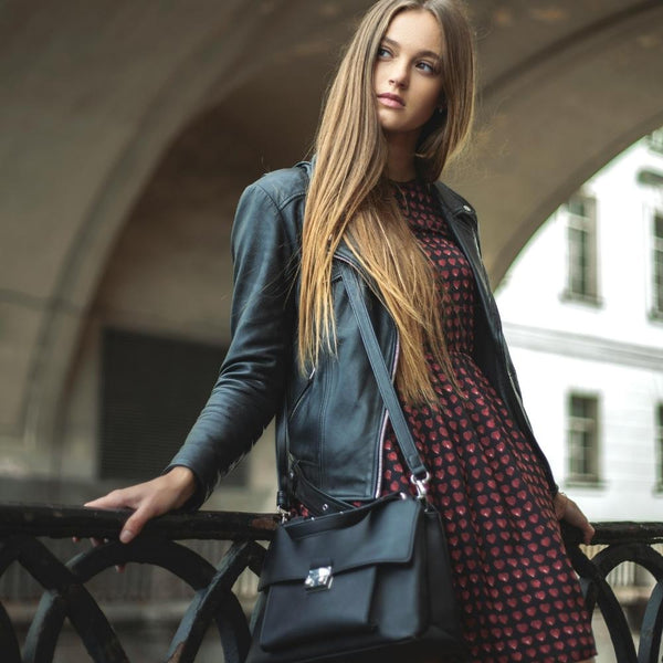 femme dans la rue portant un sac en cuir