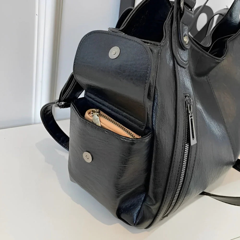 Détail de la poche latérale à pression du sac à main noir