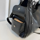Détail de la poche latérale à pression du sac à main noir