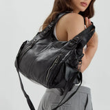 Grand sac à main noir porté à l’épaule par une femme