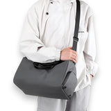 Petit sac de voyage avec compartiment chaussures gris porté en bandoulière