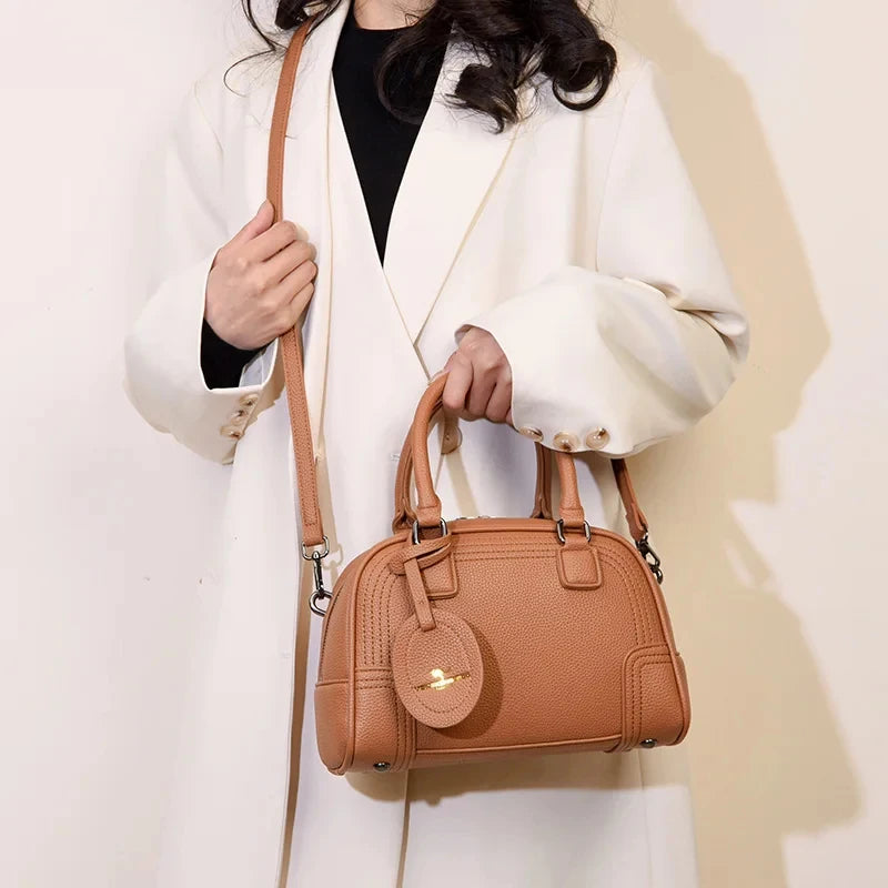 Sac à main poignées et bandoulière camel porté par femme