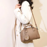 Sac à main poignées et bandoulière marron clair porté par femme