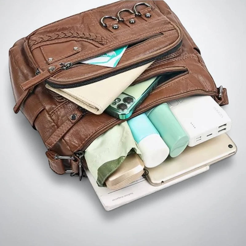 Sac bandoulière cuir souple multiples poches rempli d'affaires