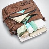 Sac bandoulière cuir souple multiples poches rempli d'affaires