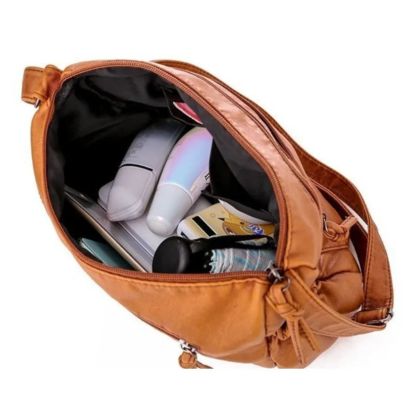 Sac bandoulière femme en cuir camel grandes poches rempli d'affaires