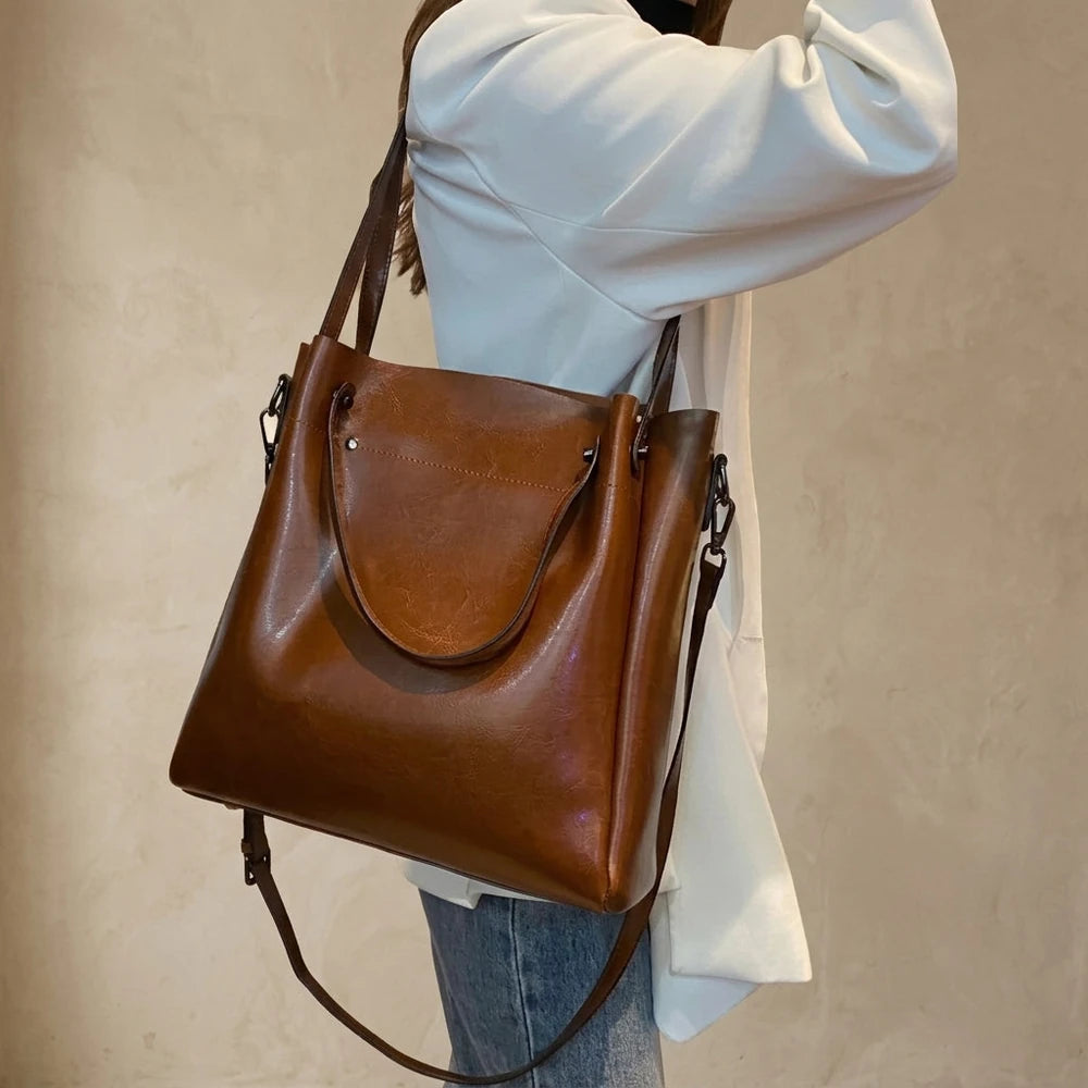 Sac cabas femme en cuir véritable camel porté à l’épaule sur fond beige
