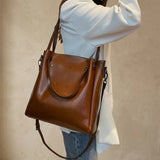 Sac cabas femme en cuir véritable camel porté à l’épaule sur fond beige