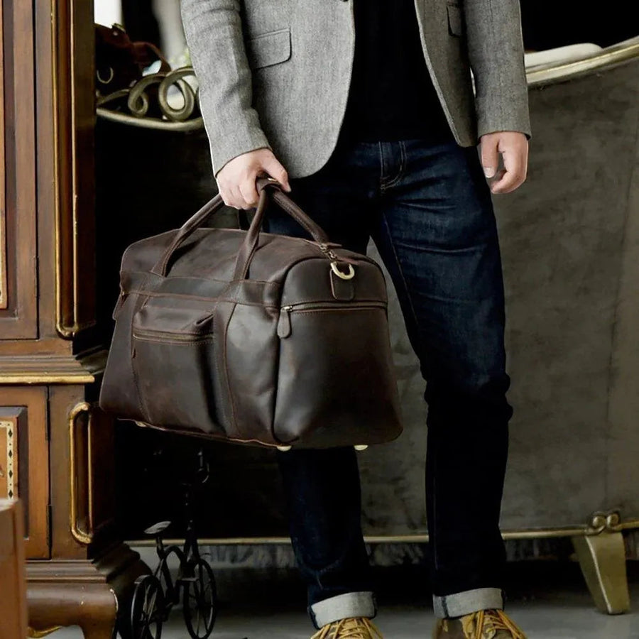 Sac de voyage en cuir véritable vintage, porté à la main par homme
