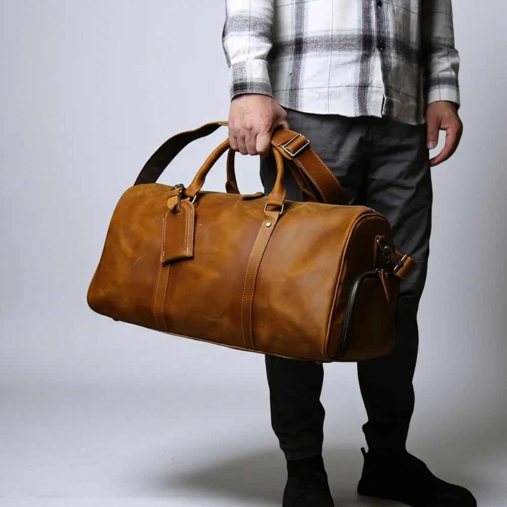 Sac de voyage homme cuir vintage camel porté à la main