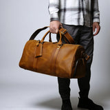 Sac de voyage homme cuir vintage camel porté à la main