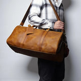 Sac de voyage homme cuir vintage camel porté en bandoulière