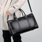 Sac de voyage imitation crocodile noir porté en bandoulière