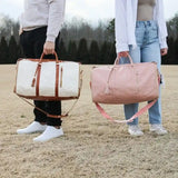 Sac de voyage pliable en similicuir blanc cassé porté à la main