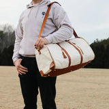 Sac de voyage pliable en similicuir blanc cassé porté en bandoulière
