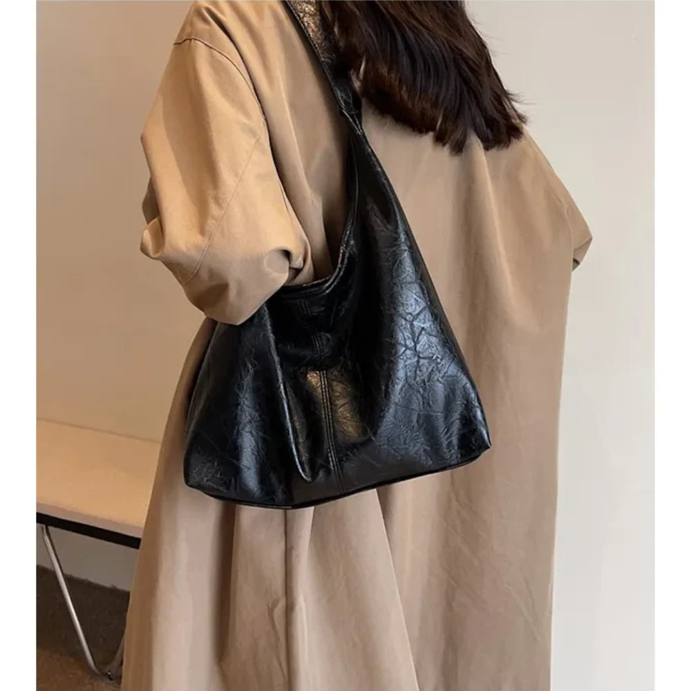 Sac fourre-tout souple cuir noir porté par femme