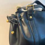 Gros plan sur les boucles dorées du sac à main vintage noir