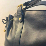 Détail du simili cuir noir et des finitions dorées du sac vintage