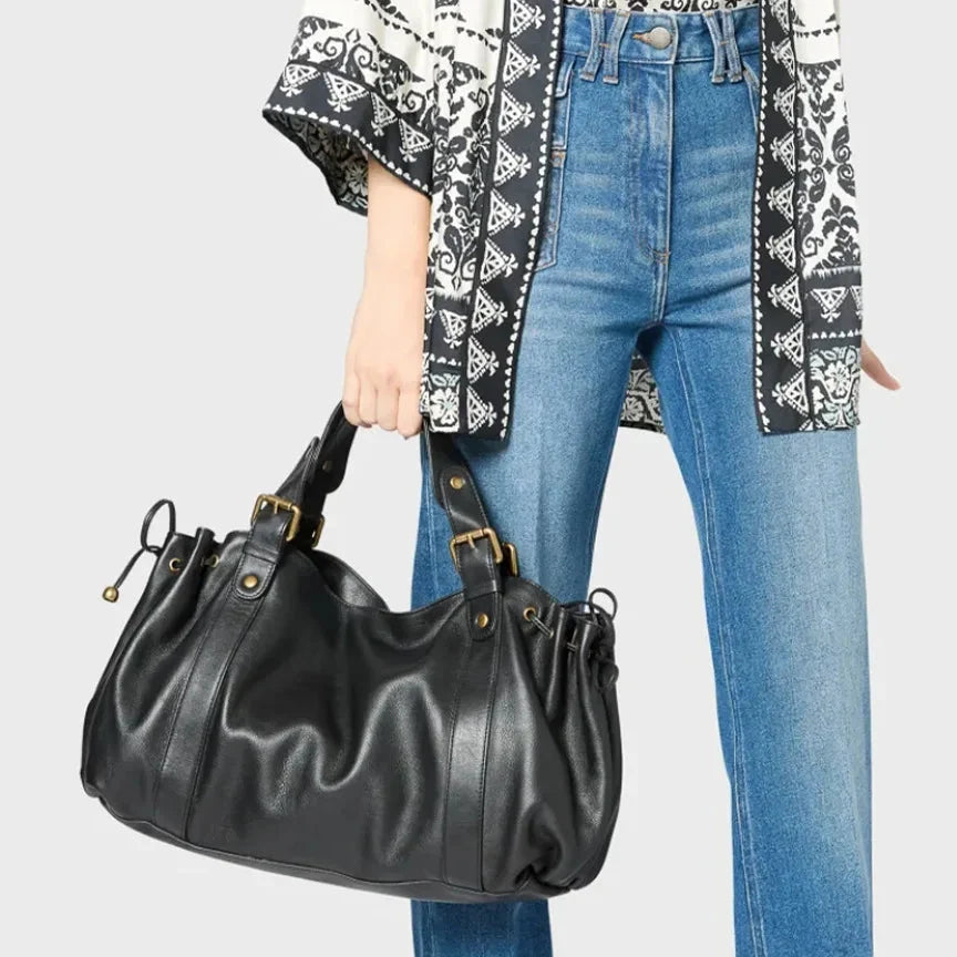 Sac à main vintage noir porté avec un jean