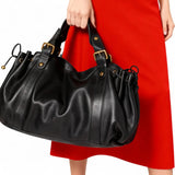 Sac à main vintage noir porté à la main avec une robe rouge