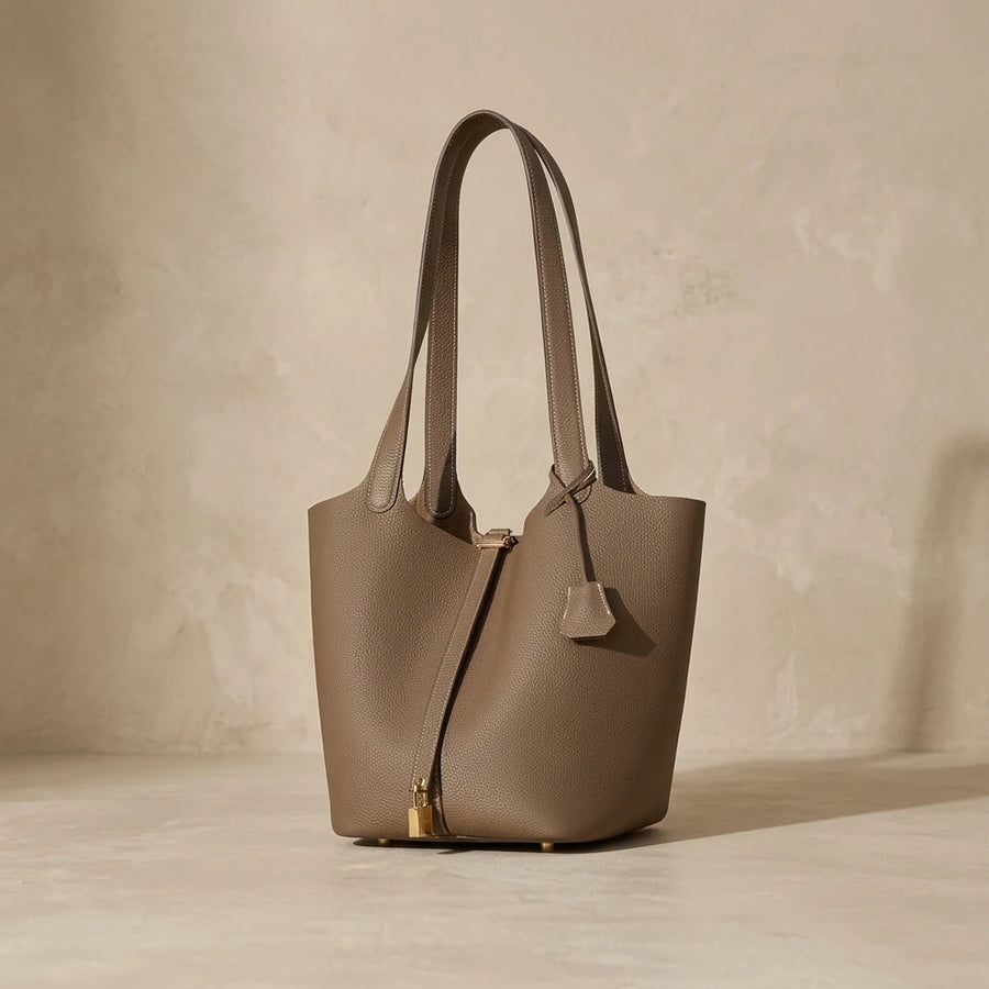 Sac seau femme en cuir véritable posé sur fond studio beige