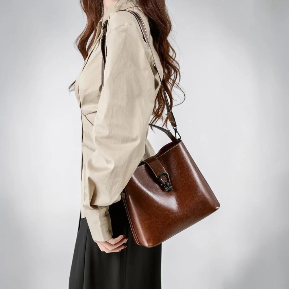 Sac seau femme en cuir ciré marron, porté à l'épaule