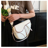 sac à main selle de cheval en simili cuir blanc porté par femme en bandoulière