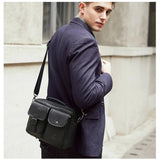 Homme portant un sac bandoulière Le Sac Bandoulière en cuir noir véritable style rétro avec poches frontales